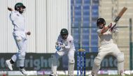 New Zealand batsman BJ Watling (R) plays a shot as Pakistani wicketkeeper captain Sarfraz Ahmed (C) looks on during the second day of the third and final Test cricket match between Pakistan and New Zealand at the Sheikh Zayed International Cricket Stadium