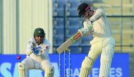 New Zealand captain Kane Williamson (R) plays a shot as Pakistani wicketkeeper captain Sarfraz Ahmed looks on during the third day of the third and final Test cricket match between Pakistan and New Zealand at the Sheikh Zayed International Cricket Stadium