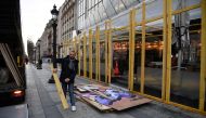 Workers remove wooden wall to protect the drugstore publicis shop near the Arc de Triomphe in Paris, on December 9, 2018 a day after a 