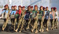 Members of Iraq's Rapid Response military unit hold portraits of fallen soldiers during the fight against Islamic State (IS) group during a ceremony at a military base inside Baghdad's International Airport, to mark the first anniversary of the country's 