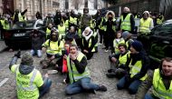 Protesters wearing yellow vests sit on the floor during a demonstration by the 