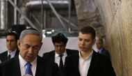 Yair Netanyahu observes his father Israeli Prime Minister Benjamin Netanyahu reading a prayer at the Western Wall in Jerusalem' Old City. (Ronen Zvulun / Reuters)