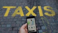 FILE PHOTO: A photo illustration shows the Uber app and a taxi sign in London, Britain, June 26, 2018. REUTERS/Simon Dawson