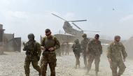 In this file photo taken on August 12, 2015 US army soldiers walk as a NATO helicopter flies overhead at coalition force Forward Operating Base (FOB) Connelly in the Khogyani district in the eastern province of Nangarhar. / AFP / Wakil KOHSAR 