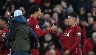 Liverpool's Brazilian midfielder Roberto Firmino (R) takes the match ball and puts it under his sirt following the English Premier League football match between Liverpool and Arsenal at Anfield in Liverpool, north west England on December 29, 2018. AFP / 