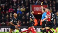 English referee Paul Tierney shows a yellow card to Manchester City's Belgian defender Vincent Kompany (L) during the English Premier League football match between Southampton and Manchester City at St Mary's Stadium in Southampton, southern England on De