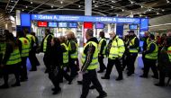 Members of Germany's union Verdi wear yellow vests as they march in front of Gate A of Duesseldorf Airport during a strike by Verdi, which called on security staff at Duesseldorf, Cologne and Stuttgart airports to put pressure on management in wage talks,