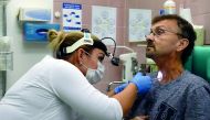 Czech doctor Barbora Repova, who leads the project of a new hi-tech voice app on behalf of Charles University, inspects a hole in the throat of her patient, Martin Kozel, on December 07, 2018 at Motol hospital, in Prague. AFP / Michal Cizek
