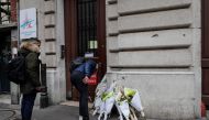 A man lays flowers outside the Paris Fire station in the 9th arrondissement of Paris, in tribute to the two firefighters killed the day before in a powerful gas explosion which tore through a building in central Paris on January 13, 2019.  AFP / Thomas SA