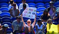 A spectator holds up a placard during the women's singles match between Germany's Angelique Kerber and Slovenia's Polona Hercog on day one of the Australian Open tennis tournament in Melbourne on January 14, 2019. AFP / William West