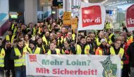 Members of Germany's Verdi union hold a banner reading 