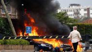 Cars are seen on fire at the scene where explosions and gunshots were heard at the Dusit hotel compound, in Nairobi, Kenya January 15, 2019. REUTERS/Thomas Mukoya