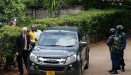 Zimbabwean cleric and activist Evan Mawarire (2nd L) is escorted to a car by Zimbabwean policemen on January 16, 2019, after he was picked up from his home in Avondale, Harare.   AFP / Jekesai NJIKIZANA