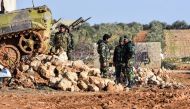 Syrian soldiers stand next to a deployed infantry-fighting vehicle at a government forces' position in the village of Hawshariya, northeast of the northern town of Manbij, on January 12, 2019. / AFP / George OURFALIAN