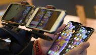 A customer compares the sizes of the latest iPhones at an Apple store in Sydney on September 21, 2018. AFP/Saeed Khan