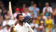 (FILES) In this file photo taken on January 3, 2019, India's Cheteshwar Pujara kisses his helmet after reaching his century (100 runs) during the first day of the fourth and final cricket Test against Australia at the Sydney Cricket Ground in Sydney. AFP 