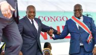 Democratic Republic of the Congo's newly inaugurated President Felix Tshisekedi (R) walks off the podium with outgoing President Joseph Kabila after he was officially handed over the instruments of power during his inauguration ceremony at the Presidency 