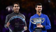 Serbia's Novak Djokovic (R) celebrates with the championship trophy during the presentation ceremony after his victory against Spain's Rafael Nadal (L) in the men's singles final on day 14 of the Australian Open tennis tournament in Melbourne on January 2