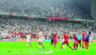 Fans throw bottles and flip-flops at the pitch as players take evasive action during the AFC Asian Cup semi-final at the Mohammed Bin Zayed Stadium, yesterday.