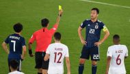 Uzbek referee Ravshan Irmatov (2nd-L) presents a yellow card to Japan's defender Maya Yoshida (2nd-R) during the 2019 AFC Asian Cup final football match between Japan and Qatar at the Mohammed Bin Zayed Stadium in Abu Dhabi on February 1, 2019. / AFP / Kh