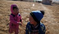 Ukhaanzaya Gankhuyag, 5, and Namuun (R), 5, play outside their Mongolian ger in Tov province outside Ulaanbaatar, Mongolia January 30, 2019. Picture taken January 30, 2019. REUTERS/B. Rentsendorj