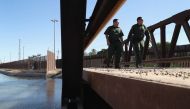 US Border Patrol agents walk over a canal of water flowing into Mexico at the US Mexico border fence on November 17, 2016 in San Luis, Arizona John Moore / Getty Images / AFP