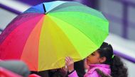 A young fan takes cover under an umbrella as rain stops play during the opening day of the Qatar Total Open 2019 at the Khalifa Tennis Complex yesterday. Pic: Baher Amin/ The Peninsula