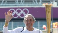 (FILES) In this file photo taken on July 25, 2012 England's former international goalkeeper Gordon Banks carries the Olympic Torch in front of Wembley Stadium in west London on July 25, 2012 two days before the start of the London 2012 Olympic Games. AFP 