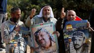 FILE PHOTO: Demonstrators hold posters depicting Yasser Arafat during a rally marking the 14th anniversary of his death near Hebron in the occupied West Bank, November 11, 2018. Reuters/Mussa Qawasma
