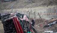 Police and investigators examine the wreckage of a bus at the crash site in the village of Laskarci, west of Skopje, on February 14, 2019.  AFP / Robert Atanasovski
