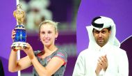 Champion Elise Mertens poses with the Qatar Total Open winner’s trophy on the podium next to President of the Qatar Tennis Federation Nasser Al Khelaifi, on Saturday.