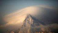 A cloud partially covers the tip of the Rock of the British territory of Gibraltar at sunrise from La Atunara port  in Algeciras bay, La Linea de la Concepcion in southern Spain August 18, 2013. Reuters/Jon Nazca