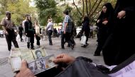 A money changer displays US and Iranian banknotes at the Grand Bazaar in central Tehran, October 7, 2015. Reuters/Raheb Homavandi