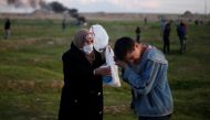 A woman helps a Palestinian boy after inhaling tear gas fired by Israeli troops during a protest at the Israel-Gaza border fence, east of Gaza City February 22, 2019. Reuters/Mohammed Salem 
 