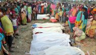 People stand next to the bodies of tea plantation workers, who died after consuming bootleg liquor, in Golaghat in the northeastern state of Assam, India, February 22, 2019. REUTERS/Stringer 