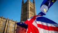 An anti-Brexit protester wearing a European Union flag cap, flies European and Union flags outside the Houses of Parliament in London on February 21, 2019. AFP / Tolga Akmen 