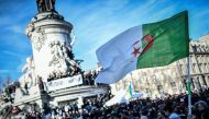 A protester holds up the Algerian flag during a rally against the Algerian president's bid for a fifth term in office on February 24, 2019 at the Place de la Republique in Paris.  AFP / STEPHANE DE SAKUTIN
