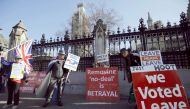Anti-Brexit activists (L) and pro-Brexit activists demonstrate outside of the Houses of Parliament in London on February 25, 2019.  AFP / Tolga Akmen
