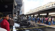 Fire fighters and onlookers gather at the scene of a fiery train crash at the Egyptian capital Cairo's main railway station on February 27, 2019.  AFP / Ahmad Hassan