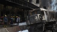 Fire fighters and onlookers gather at the scene of a fiery train crash at the Egyptian capital Cairo's main railway station on February 27, 2019.  AFP / STRINGER
