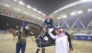 Secretary-General of Qatar Equestrian Federation (QEF), Badr Al Darwish, presenting the winner's award to Bertram Allen.  