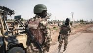 FILE PHOTO: Soldiers of the 7th Division of the Nigerian Army stand by the road in Damboa, Borno State, northeast Nigeria, on March 25, 2016. AFP/Stefan Heunis