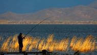 Fishermen fish on the dock at Dojran lake in Dojran, North Macedonia March 2, 2019. Reuters/Ognen Teofilovski