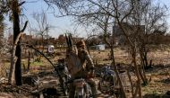 Fighters with the Syrian Democratic Forces (SDF) sits on a motorcycle at a makeshift camp for Islamic State (IS) group members and their families in the town of Baghouz, in the eastern Syrian province of Deir Ezzor, on March 9, 2019. / AFP / Dylan COLLINS