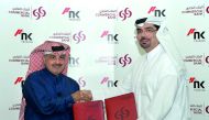 Commercial Bank of Qatar Chief Marketing Officer Hussain Al Abdulla (right) exchanges documents with former Qatari Rally Champion Nasser Al Atya after they signed a sponsorship agreement during a press conference held at the Commercial Bank Plaza in West 