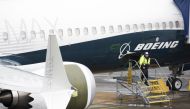 A worker is pictured next to a Boeing 737 MAX 9 airplane on the tarmac at the Boeing Renton Factory in Renton, Washington on March 12, 2019. AFP / Jason Redmond