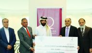 Ali Al Gharib, Director of Programs and Public Relations Department at Qatar Charity, receiving donation from the Pakistani businesspersons in the presence of Ahmed Hussein, President of the Pakistan Welfare Forum, and other members.