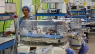 A photo taken March 11, 2019, shows a nurse checking on babies inside incubators at the maternity ward of the Rabta hospital in Tunis.  AFP / Fethi Belaid 