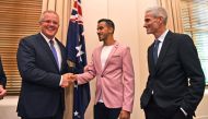 Australia's Prime Minister Scott Morrison (L) shakes hands with Hakeem al-Araibi (C), who was granted refugee status and residency in Australia in 2017 after fleeing Bahrain, next to former Australian football player Craig Foster (R) after al-Araibi becam