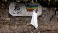 FILE PHOTO: A traditionally-dressed Ethiopian woman walks past a mural depicting Ethiopia's Emperor Tewodros II in Addis Ababa, Ethiopia, June 1, 2007. REUTERS/Andrew Heavens